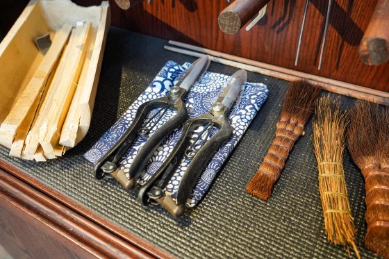 Pruning shears lying on a blue and white patterned cloth. 